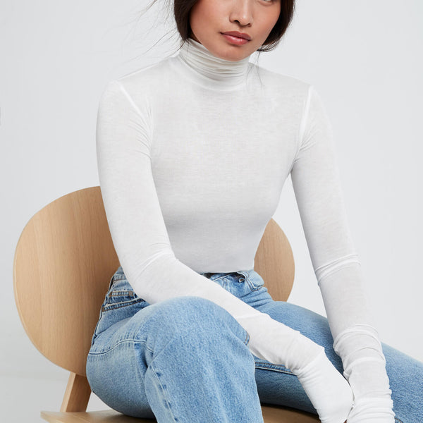 https://www.marcellanyc.com/cdn/shop/products/eloise-sheer-turtleneck-top-marcella-nyc-off-white-seated_ee3413b8-e070-468a-9754-1a2fb3c5203f_600x600_crop_center.jpg?v=1631569114